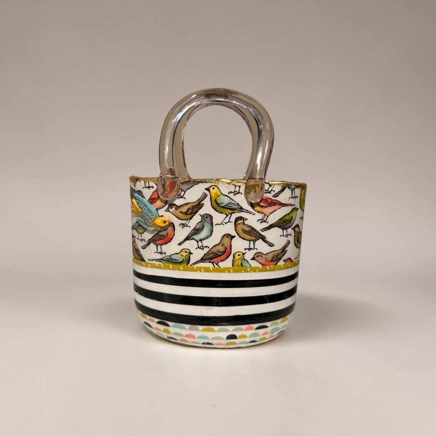 Glass purse vase with bird pattern and black and white stripes on a white background