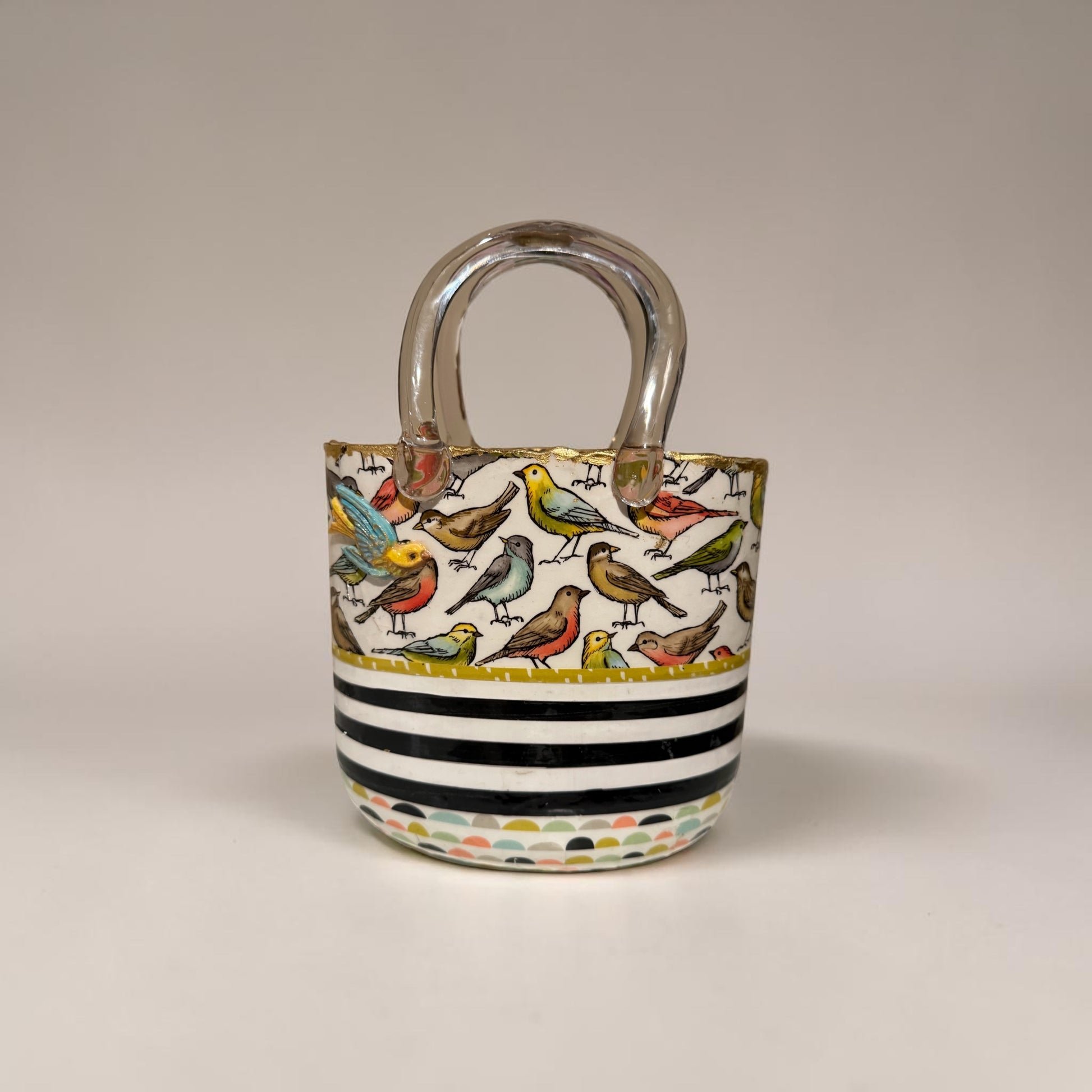 Glass purse vase with bird pattern and black and white stripes on a white background