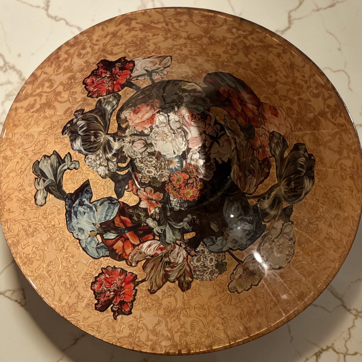 The inside of a round decorative bowl with a floral vase design.