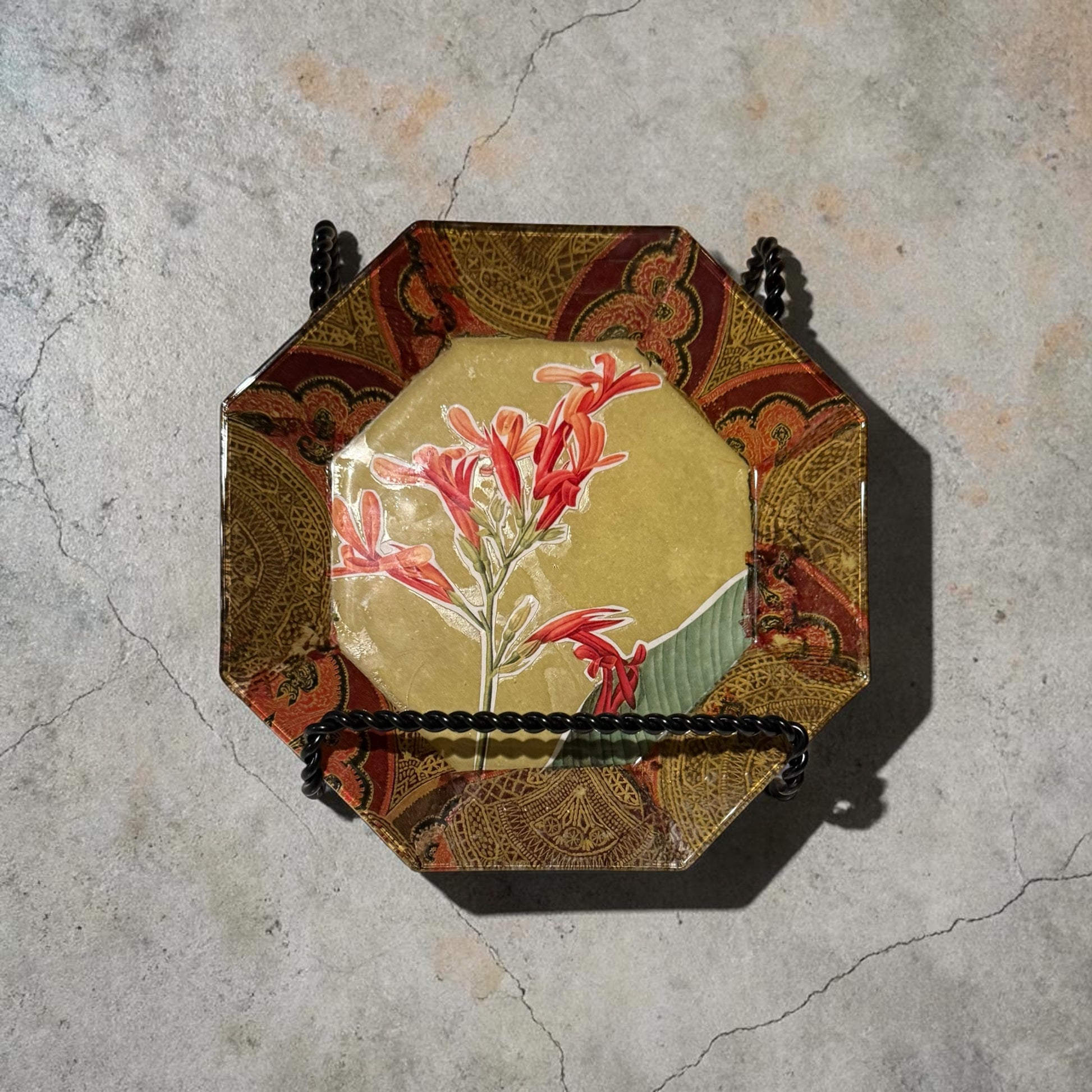 Decorative plate with a large freesia flower on a light marbled counter.
