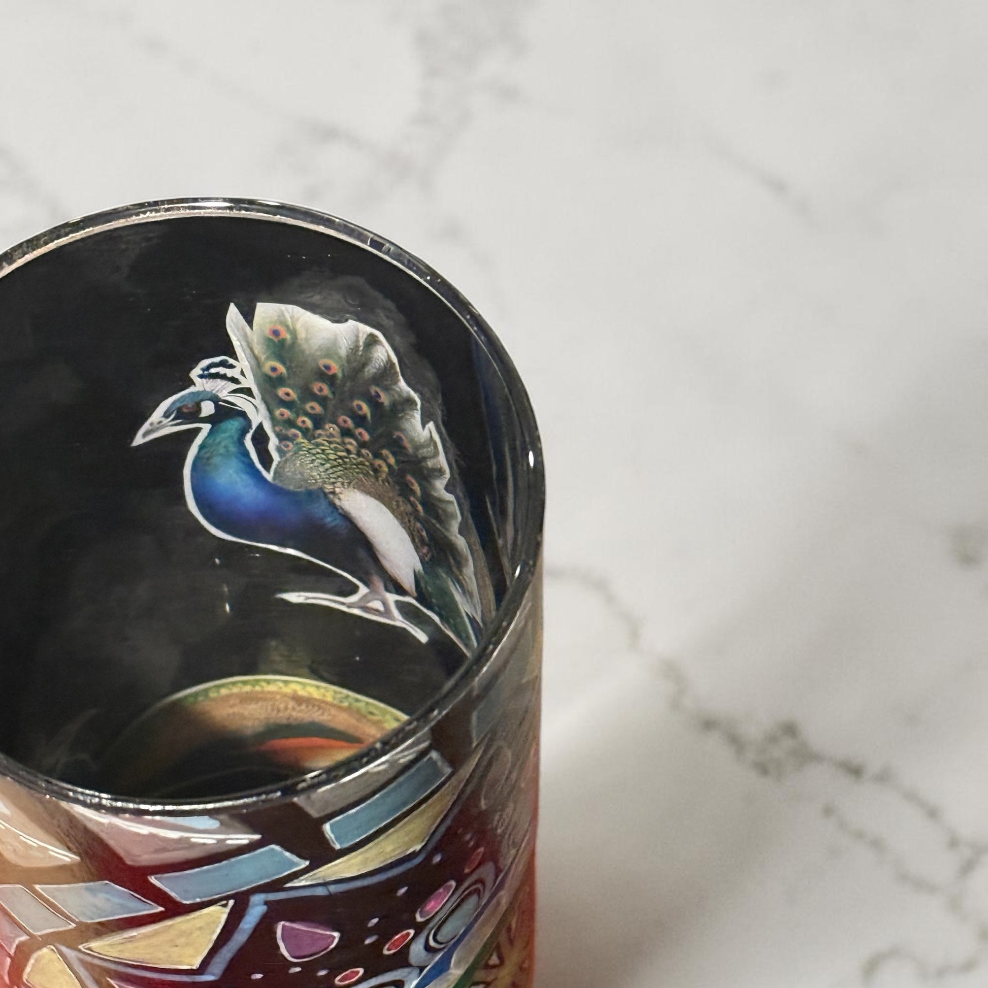 The inside of a cylindrical vase decorated with a peacock on a white marbled counter