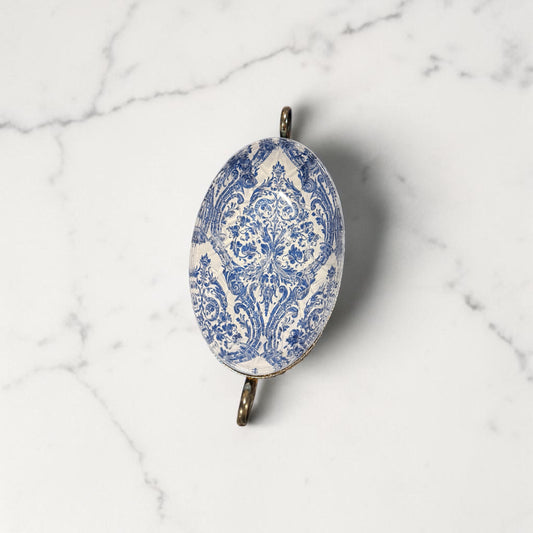 Decorative oval dish with blue and white pattern on a marble surface
