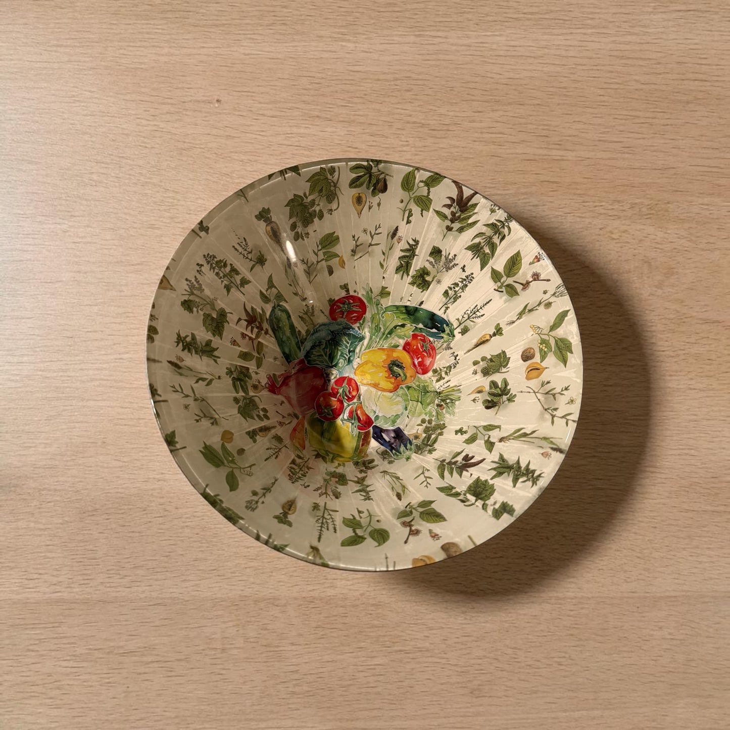 Inside of a large bowl decorated with a vegetable design.